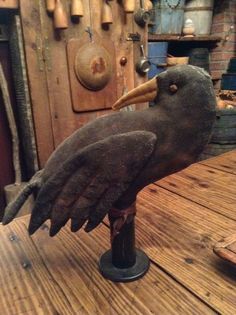 a wooden table topped with a statue of a bird on top of it's head