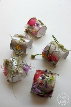 four pieces of paper with flowers on them sitting next to each other in the shape of cubes