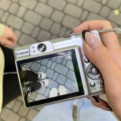 a person is holding a camera and taking a picture with their cell phone while sitting on the ground