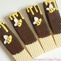 four pieces of chocolate and vanilla ice cream with honeycombs on them are arranged in the shape of bees