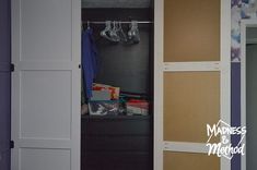 an open closet with clothes hanging on the door and other items in front of it