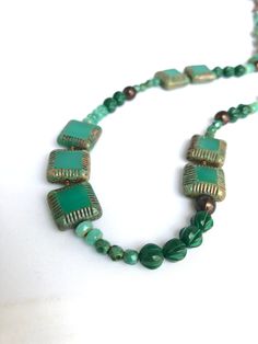 Now that I have a great variety of beads in my stash I'm able to create funky, monochromatic pieces. These beads are all a great variety of jade green - love all the fun shapes and textures!  The great thing about pieces like this is how easy it is to match with something you already have - with a variety of shades of color the match does not have to be exact. Wear it with a dark color and the light beads stand out... wear it with a light color and the dark beads stand out. The metal I use is natural brass. It is nickel-free, lead-free compliant and made in the USA - Hooray! The total length is 34 inches. Enjoy! Green Czech Glass Necklaces With Faceted Beads, Green Single Strand Necklace Made Of Czech Glass, Green Single Strand Czech Glass Necklace, Artisan Green Czech Glass Beaded Necklaces, Single Strand Green Czech Glass Beads, Artisan Green Beaded Necklace With Czech Glass, Adjustable Green Czech Glass Beaded Necklaces, Green Czech Glass Necklace With Faceted Beads, Artisan Green Czech Glass Beaded Necklace