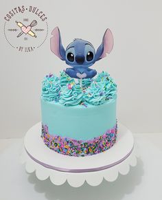 there is a blue cake with sprinkles on it and an elephant figurine