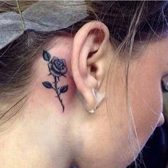 a woman with a small tattoo on her neck and behind the ear is a rose