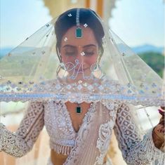 a woman wearing a veil and holding an umbrella over her head with the word aa on it