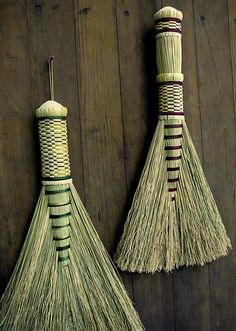 two brooms are hanging on the wall