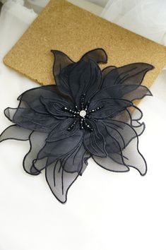 a black flower on a white table cloth