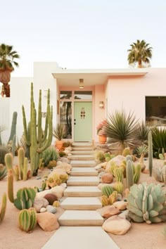 a house with cactus plants and rocks in front of the door, along with steps leading up to it