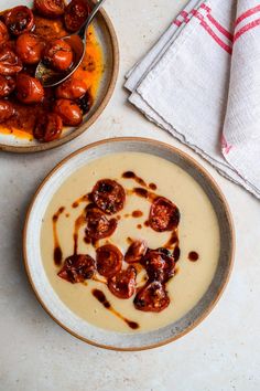 two bowls filled with food on top of a white counter next to a red and white towel