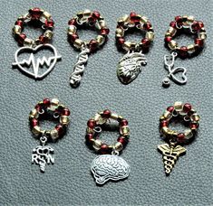 several different types of bracelets and charms on a gray surface with the word god written in silver