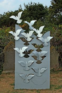 a metal sculpture with white birds on it