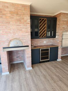 an empty kitchen with wood floors and black cabinets