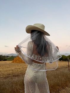 a woman in a white dress and cowboy hat