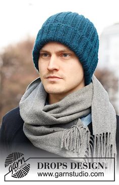 a man wearing a hat and scarf with a blue knitted beanie on his head