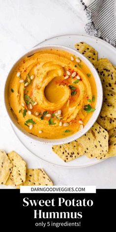 sweet potato hummus in a white bowl surrounded by crackers