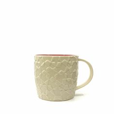 a white coffee cup with red rims on a white background, in the shape of an abstract design