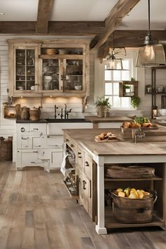 a large kitchen with wooden floors and white cabinetry is pictured in this image, there are baskets on the island