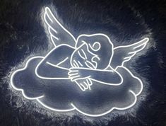 a neon sign with an angel sleeping on it's back and arms crossed in the air