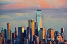 the skyline of new york city at sunset with one world trade center in the foreground