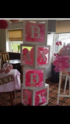 pink and white baby blocks are stacked on top of each other in front of a window