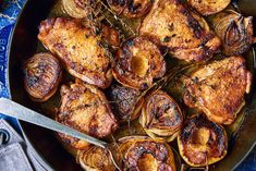 a skillet filled with cooked chicken and onions on top of a blue table cloth