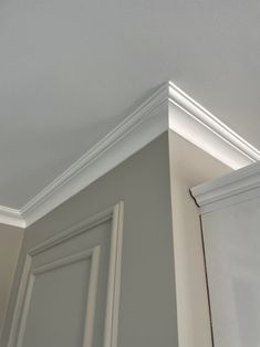 the corner of an empty room with white trim and molding on the wall above it