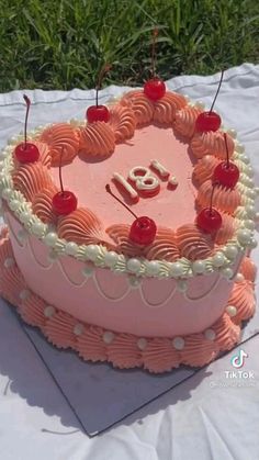 a pink birthday cake with cherries and the number eighteen on it's top