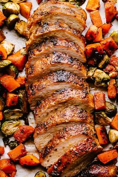 sliced pork and roasted vegetables on a white platter