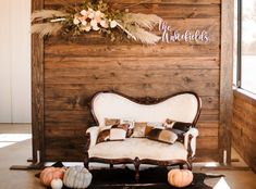 a couch and some pumpkins in front of a wooden wall