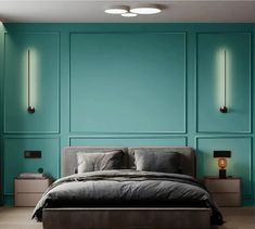 a large bed sitting under two lamps in a bedroom next to a wall with blue walls