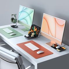 two computer monitors sitting on top of a desk next to a keyboard and mouse pad