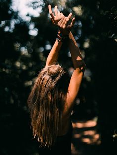 a woman reaching up into the air with her hands