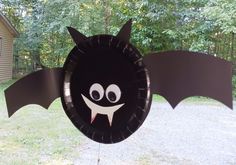 a black bat shaped paper plate sitting on top of a yard