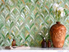 two vases with flowers in them sitting on a table next to a wallpaper