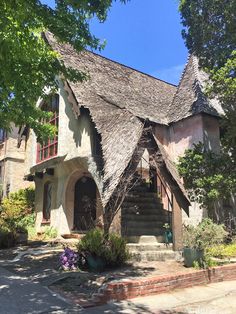 an old style house with a thatched roof and steps leading up to the front door