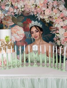 a woman sitting in front of a cake surrounded by candles