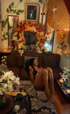 a woman sitting on top of a couch in front of a fireplace covered in flowers