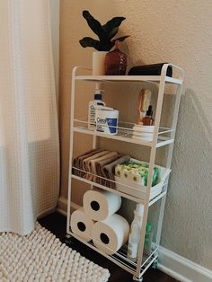 a bathroom shelf filled with toilet paper and other items