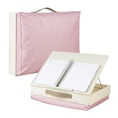 a pink binder with a notepad and pen in it next to a white box