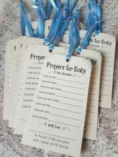 four prayer cards with blue ribbons attached to them