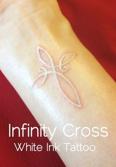 a white ink tattoo on someone's wrist that says, infinity cross