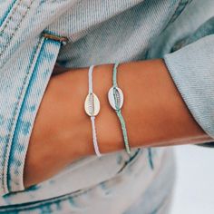 Our Cowrie Bracelet is every beach babe’s dream! Available in two color combos—white with gold and winter fresh with silver—this bitty braid bracelet perfectly complements your sea-inspired style, and looks epic when paired with our other Cowrie designs. - White: Silver-Plated Brass- Winter fresh: Gold-Plated Brass- Charm Dimensions: 14mm (L) x 10mm (W)- Adjustable from 2-5 Inches in Diameter Two Color Combos, Braid Bracelet, Pura Vida Bracelets, Hang Ten, Sea Inspired, Pinky Promise, Brass Charms, 30 Gifts, Chain Anklet