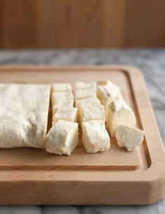 sliced up cheese on a cutting board next to a knife