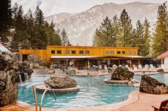 an outdoor swimming pool surrounded by rocks and trees