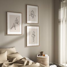 three framed pictures hang on the wall above a bed in a room with beige linens