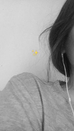 a woman with ear buds in her ears is looking at the camera and has a yellow star on it