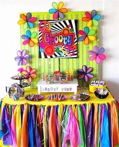 a table topped with lots of colorful ribbons and desserts next to a sign that says groozy