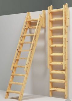 two wooden ladders are next to each other in front of a white wall and gray wall