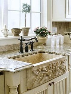 a kitchen sink sitting under a window next to a counter