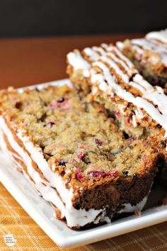 slices of cake on a plate with icing and cranberry toppings, ready to be eaten